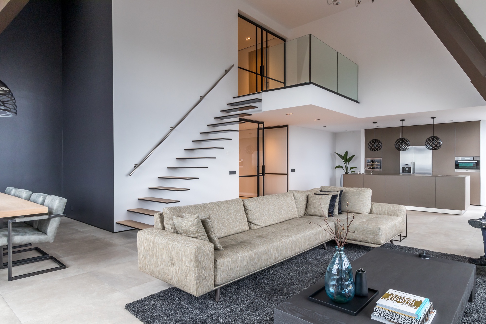 Modern interieur met zwevende stalen trap en glazen balustrade